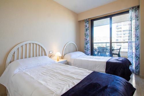 a hotel room with two beds and a window at ESPACIO 5 - Primera Línea de Playa in Cullera