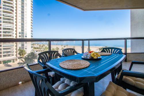 a blue table with chairs and a plate of food on a balcony at ESPACIO 5 - Primera Línea de Playa in Cullera