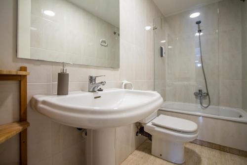 a bathroom with a sink and a toilet and a mirror at ESPACIO 5 - Primera Línea de Playa in Cullera