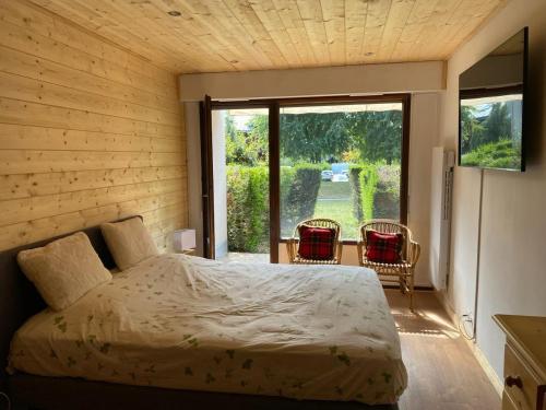 a bedroom with a bed and a large window at Multi résidences Samoëns in Samoëns
