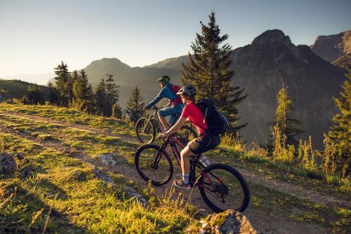 two people riding bikes on a trail in the mountains at NOVA Moments Boutique Hotel in Pertisau