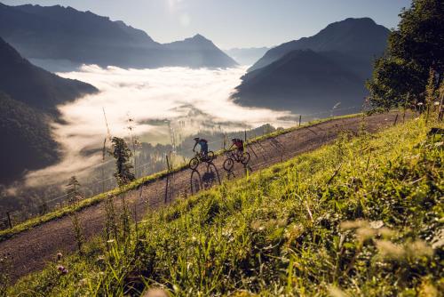 two people riding bikes on a dirt road in the mountains at NOVA Moments Boutique Hotel in Pertisau