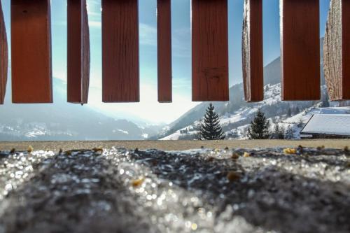 a view of a snowy mountain through a fence at Chalet Bijou in Blitzingen