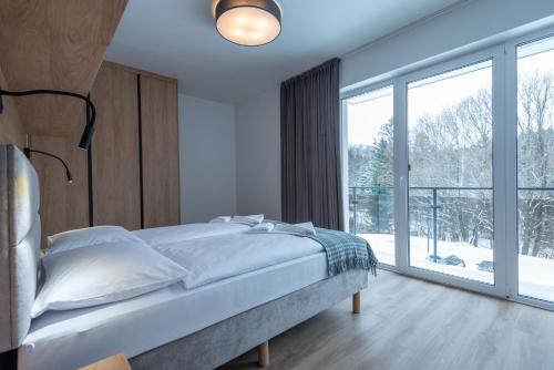 1 dormitorio con cama y ventana grande en Apartamenty na Uroczysku, en Szklarska Poręba