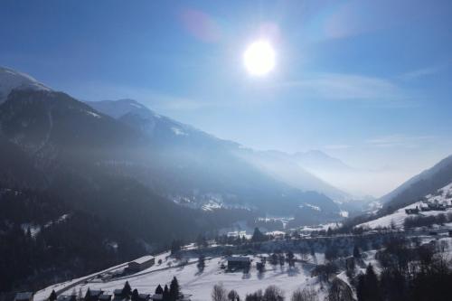 a snow covered mountain with the sun in the sky at Chalet Bijou in Blitzingen