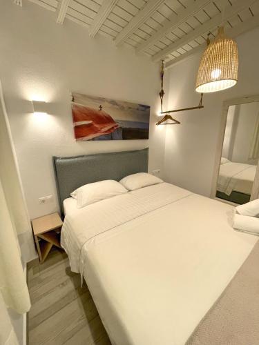 a bedroom with a large white bed and a lamp at Lefteris in Mýkonos City
