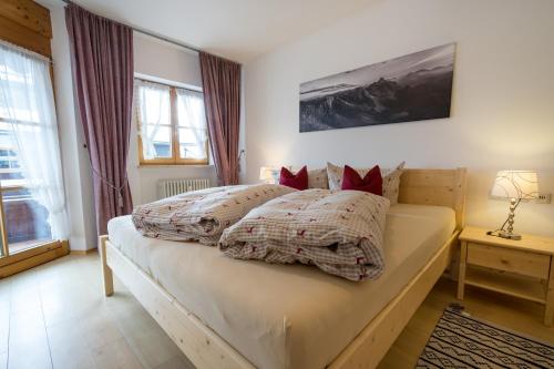 ein Schlafzimmer mit einem großen Bett mit roten Kissen in der Unterkunft Ferienwohnung Bacco in Oberstdorf