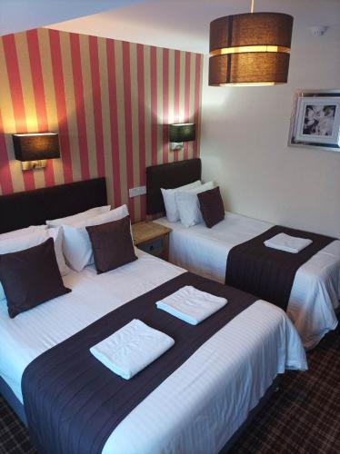a hotel room with two beds with towels on them at The Trafford Hotel in Blackpool