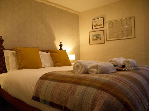 a bedroom with a large bed with towels on it at Painters at the Angel in Sudbury