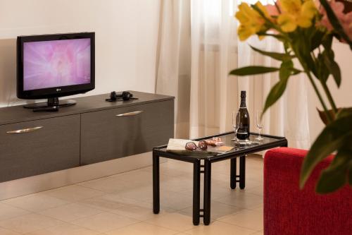 salon ze stołem i telewizorem w obiekcie Hotel Commercio & Pellegrino w Wenecji