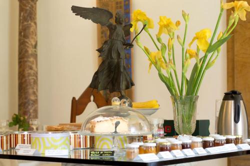 a shelf with a statue of an angel and flowers at La Casa nel Borgo in Piadena