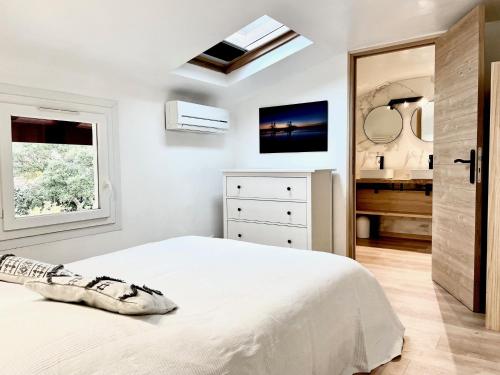 - une chambre blanche avec un lit et un lavabo dans l'établissement Appartement La Nord - Villas Lake and Sea, à Soorts-Hossegor