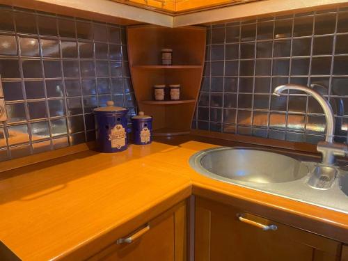 a kitchen with a sink and blue tiles on the wall at Elegante apartamento centrale in Tríkala