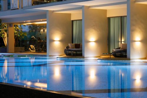 a large swimming pool in a hotel with chairs at The Signature Hotel Airport in Hat Yai