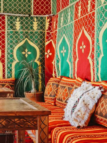 a room with a couch and a table with colorful tiles at cactus surf house in Tamraght Ouzdar