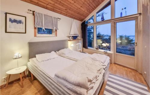 um quarto com uma cama e uma grande janela em Stunning Home In Lidkping With House Sea View em Tallbacken