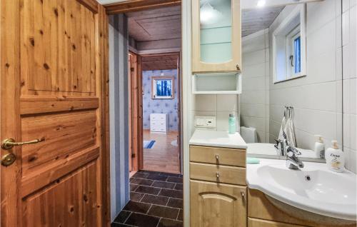 uma casa de banho com um lavatório e um espelho em Stunning Home In Lidkping With House Sea View em Tallbacken