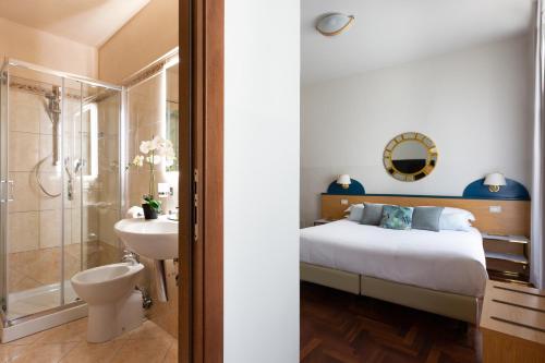 a bedroom with a bed and a shower and a sink at Aramis Rooms in Florence