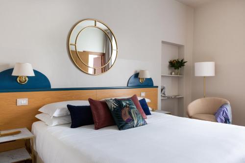a bedroom with a large white bed and a mirror at Aramis Rooms in Florence