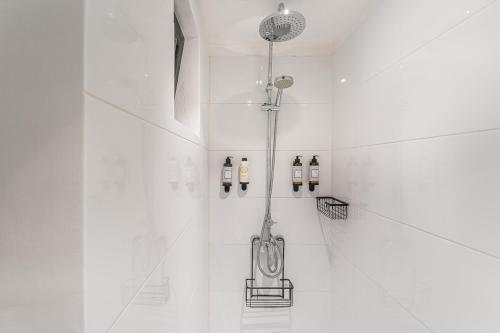 a bathroom with a shower with white tiles at GuestReady - Casa da Alegria 8 in Porto