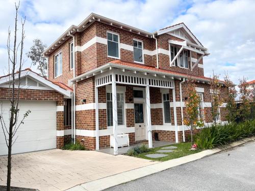una casa de ladrillo con garaje blanco en Entire stylish and bright inner city home, en Perth