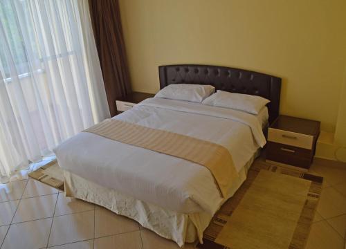 a large bed in a bedroom with a large window at Norfolk Towers Serviced Apartment -Nairobi, City Centre CBD in Nairobi