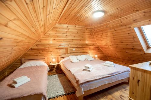 a bedroom with two beds in a wooden cabin at Chalet Markoci With Hot Tub - Happy Rentals in Rakovica