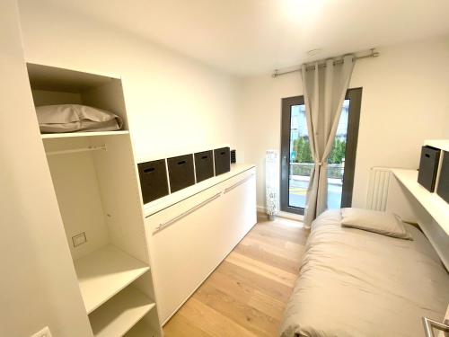 um pequeno quarto com uma cama e uma janela em Brand New Large Family Flat in Center- Parking -N1 em Luxemburgo