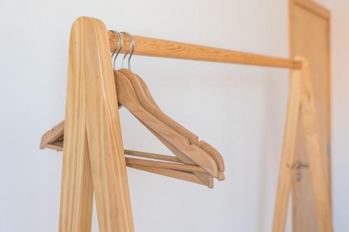 a pair of wooden hangers in a closet at GuestReady - Seven Farm in Mangualde