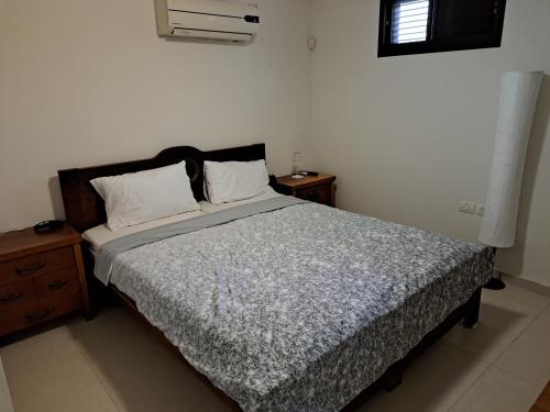 ein Schlafzimmer mit einem großen Bett mit zwei Kissen in der Unterkunft Pura vida in Aschkelon