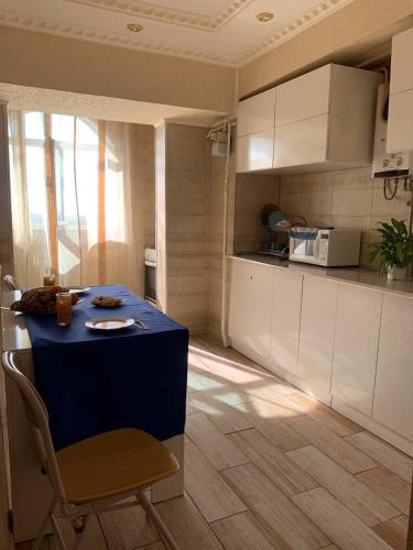 eine Küche mit einem blauen Tisch in einem Zimmer in der Unterkunft LUX in Schymkent