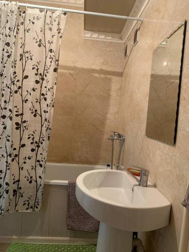a bathroom with a sink and a shower curtain at LUX in Shymkent