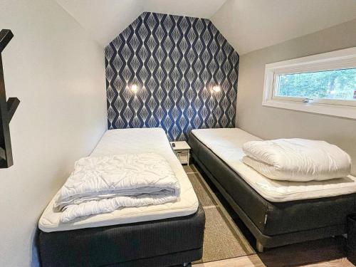 niewielka sypialnia z 2 łóżkami i oknem w obiekcie Holiday home FÄRLÖV w mieście Färlöv