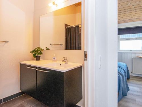 La salle de bains est pourvue d'un lavabo et d'un miroir. dans l'établissement Holiday home Gjern IV, à Gjern