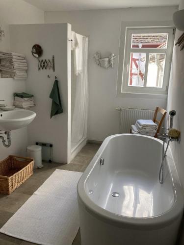 a white bathroom with a tub and a sink at Ferienwohnungen auf der Stadtmauer 
