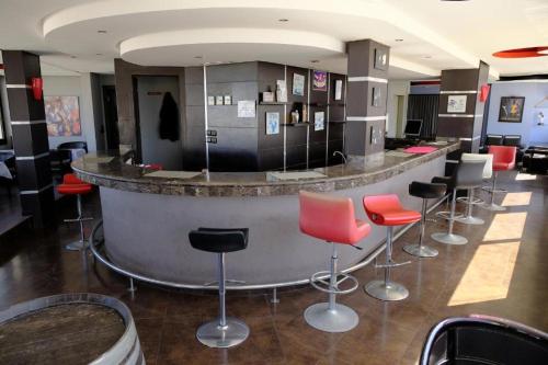 een bar met rode en zwarte krukken in een kamer bij Washington Hotel in Casablanca