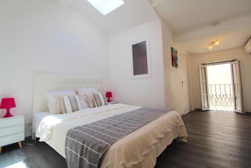 une chambre blanche avec un grand lit et une fenêtre dans l'établissement Appartement moderne à Cannes, 45 m², proche des plages, à Cannes