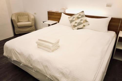 a bedroom with a bed with a stack of books on it at Waiting Homestay in Taitung City