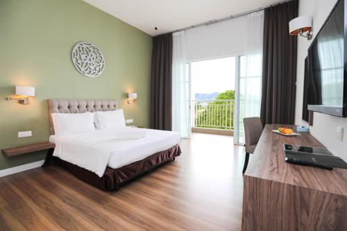 um quarto de hotel com uma cama e uma varanda em Hotel Casuarina@Kuala Kangsar em Kuala Kangsar