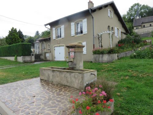 a house with a fountain in front of a yard at Gîte de la fontaine in Saint-Rémy-la-Calonne