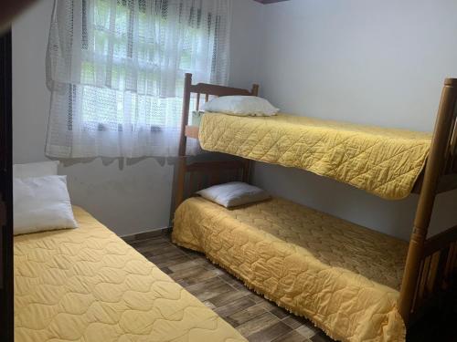 a bedroom with two bunk beds and a window at Cantinho do Sussego 2 in Campos do Jordão
