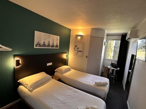 um quarto de hotel com duas camas e uma parede verde em L'Escale d'Alès HOTEL em Alès