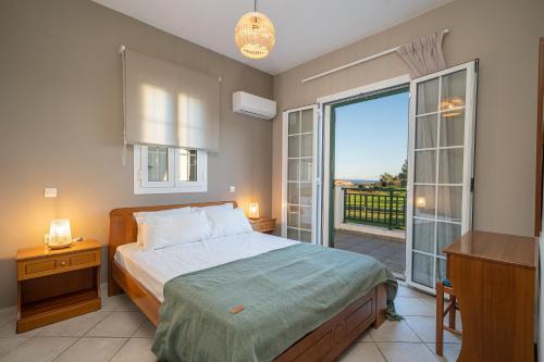 1 dormitorio con 1 cama y balcón con vistas. en Captain's Villas, en Katelios