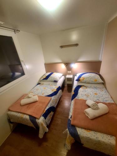 a small room with two beds and a window at Gabi Mobile home in Banj