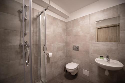 uma casa de banho com um chuveiro, um WC e um lavatório. em Hotel Felix em Cracóvia