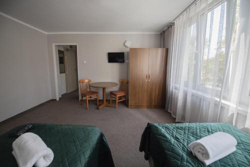 1 dormitorio con cama, mesa y ventana en Hotel Felix en Cracovia