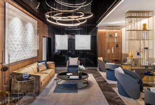 a living room with a couch and tables and chairs at Casa Baglioni Milan - The Leading Hotels of the World in Milan