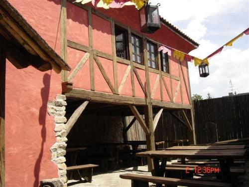 a red building with a porch and a picnic table at Penzion Hrad in Frýdek-Místek
