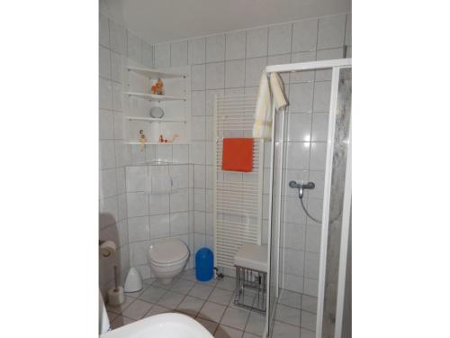 uma casa de banho com um chuveiro e um WC. em Ferienhaus Bach em Dorum Neufeld