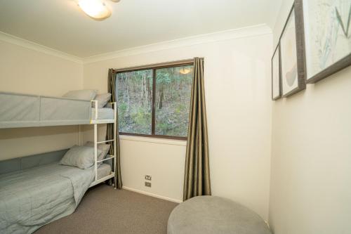 a bedroom with a bunk bed and a window at Bushland Retreat in Gold Coast